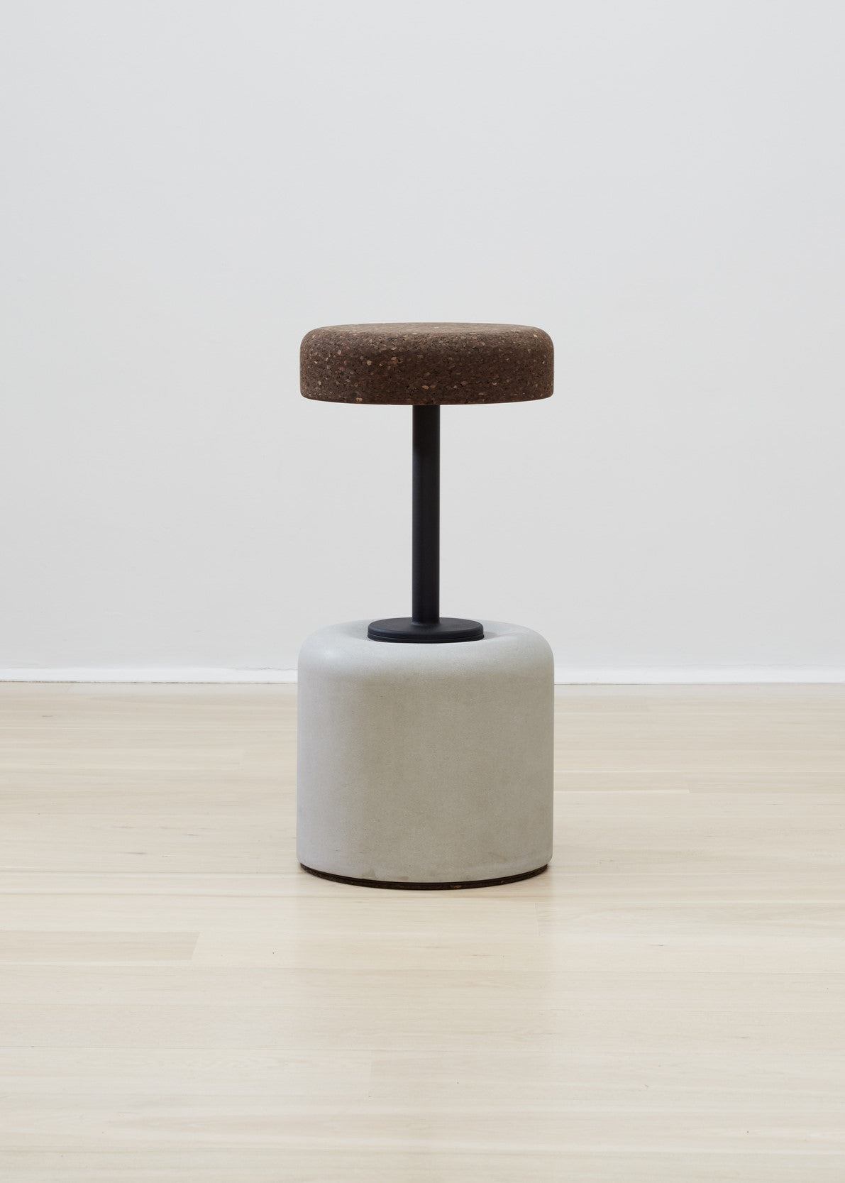 Elegant Wiid Cork and Concrete Bar Stools featuring a natural grey base paired with a dark cork seat, epitomizing modern sustainable design. This unique combination offers both aesthetic appeal and functional durability, making it a perfect addition to any contemporary kitchen or bar setting that values eco-friendly, high-quality furniture