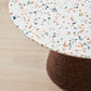 Close-up image of the exquisite terrazzo top on Kanju's Wiid Terrazzo and Cork Dining Table in Dark Cork, crafted by Wiid Design. This detailed view showcases the intricate speckled pattern and vibrant color mix, highlighting the table's luxurious and contemporary aesthetic. The terrazzo top epitomizes sustainable elegance, adding a sophisticated touch to any dining area.