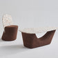 Kanju's sophisticated pairing: the Wiid Terrazzo and Cork Coffee/Side Table in Dark Cork next to the Wiid Terrazzo and Cork Dining Chair. This image captures the harmony between the two pieces, highlighting their luxurious terrazzo elements and dark cork accents. Designed by Wiid Design, the set exemplifies sustainable luxury, blending functionality with contemporary aesthetics for versatile use in modern living and dining spaces