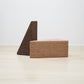 Chic set of Kanju's Wiid Painted Triangle Cork Seats, featuring contrasting finishes in both light and dark cork. This elegant duo exemplifies the versatility and sustainable design of cork furniture, offering a stylish, modern seating solution that complements a variety of interior decors with its minimalist aesthetic and eco-friendly appeal.